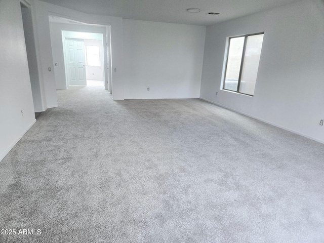 carpeted spare room with baseboards