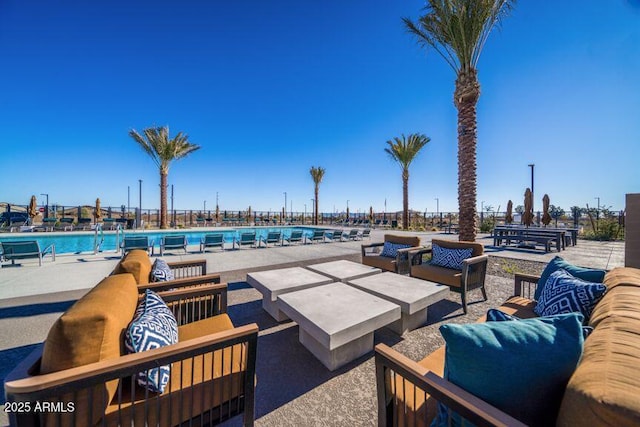 community pool with outdoor lounge area and a patio
