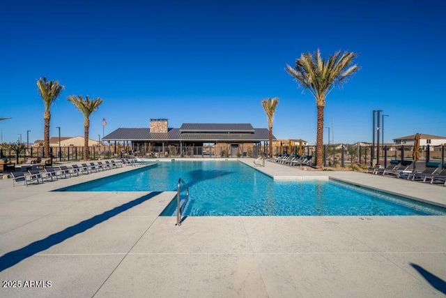 pool with a patio and fence