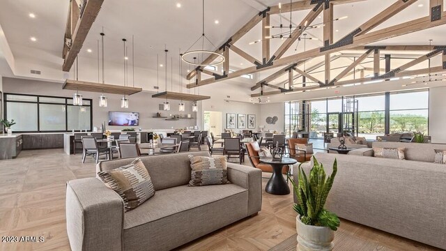 living room featuring high vaulted ceiling, an inviting chandelier, and beamed ceiling