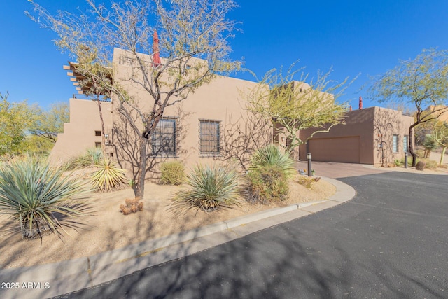 pueblo revival-style home featuring a garage