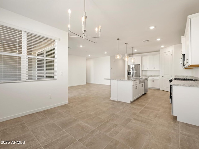 kitchen featuring white cabinetry, a center island with sink, a notable chandelier, and appliances with stainless steel finishes