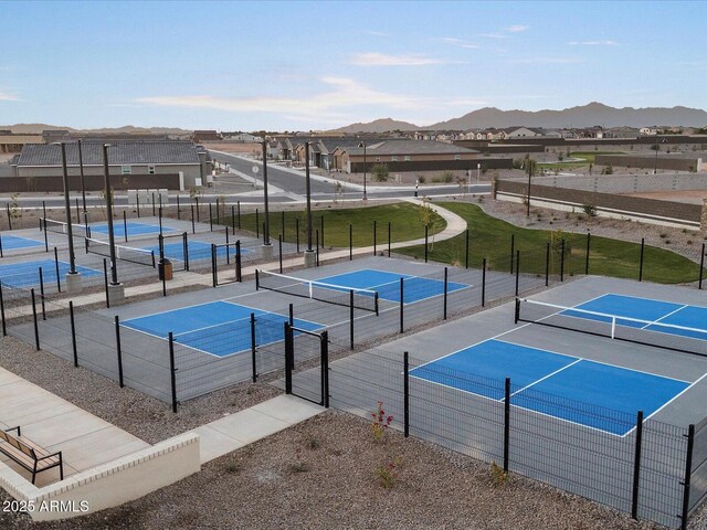 view of sport court with a residential view, a mountain view, and fence