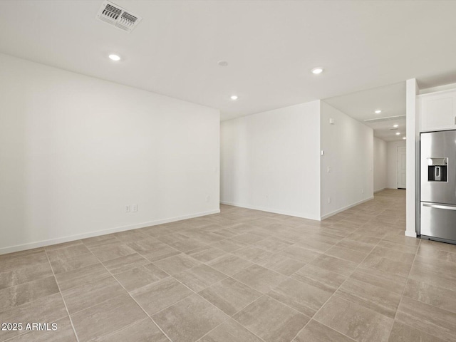 spare room with baseboards, visible vents, and recessed lighting
