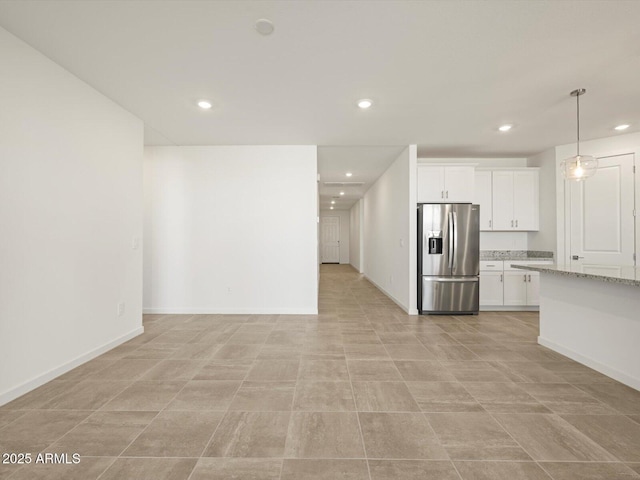 kitchen with white cabinets, light stone countertops, stainless steel fridge with ice dispenser, and recessed lighting