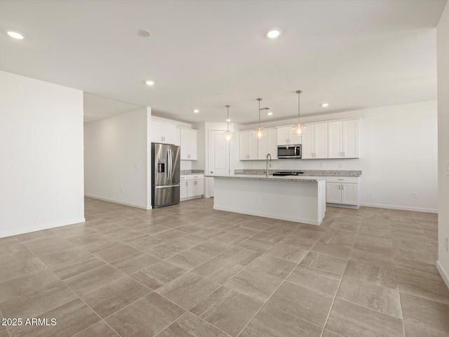 kitchen featuring white cabinetry, a sink, stainless steel appliances, and open floor plan