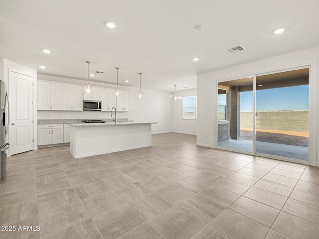 kitchen featuring a center island with sink, stainless steel appliances, visible vents, white cabinets, and recessed lighting
