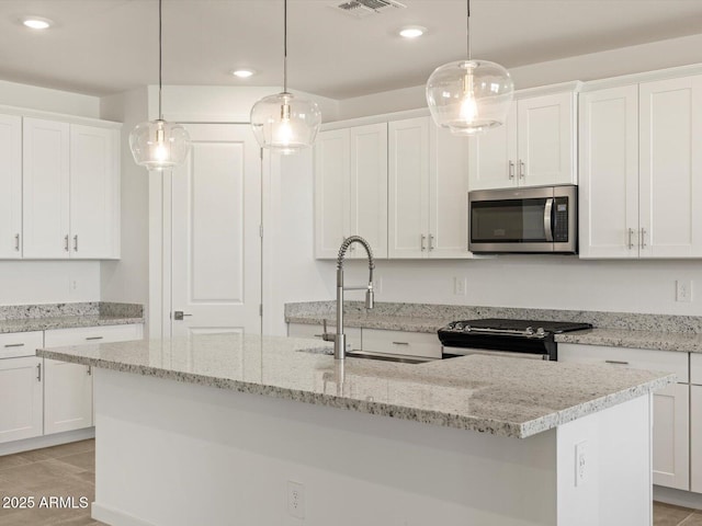 kitchen with a sink, white cabinets, and appliances with stainless steel finishes