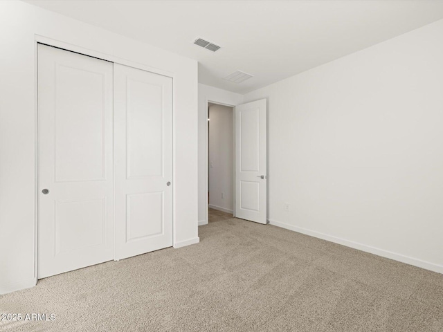 unfurnished bedroom featuring a closet, baseboards, visible vents, and carpet