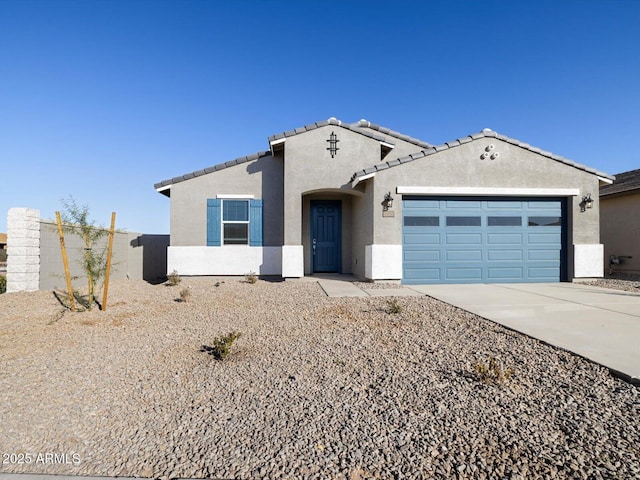 view of front of house featuring stucco siding, driveway, a garage, and a tiled roof