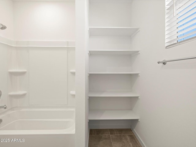 full bath with baseboards and tile patterned flooring