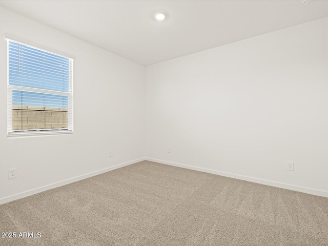 carpeted spare room with baseboards