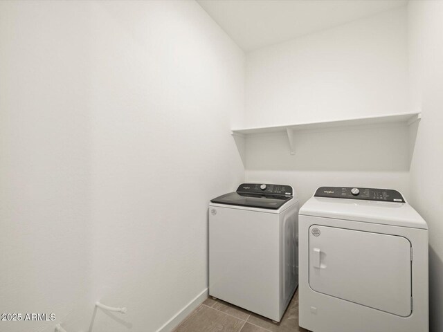 washroom featuring tile patterned floors, washing machine and dryer, baseboards, and laundry area
