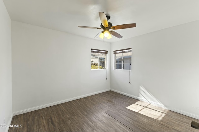 empty room with ceiling fan and dark hardwood / wood-style flooring