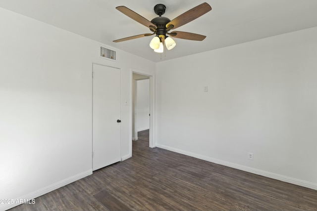 empty room with ceiling fan and dark hardwood / wood-style floors