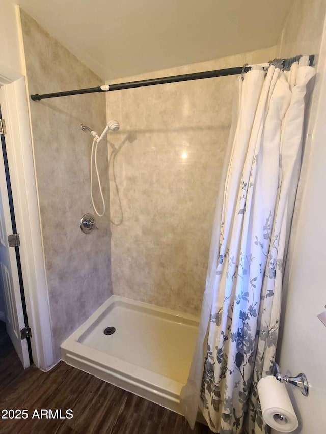 bathroom with hardwood / wood-style flooring and walk in shower