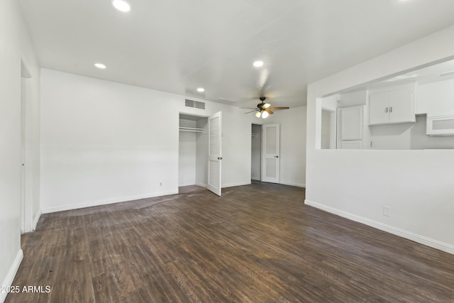 unfurnished living room featuring ceiling fan and dark wood-type flooring