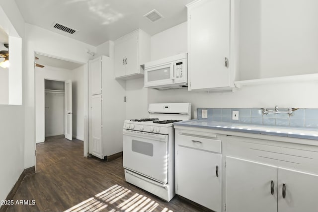 kitchen featuring white appliances, white cabinets, sink, dark hardwood / wood-style floors, and ceiling fan