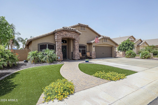 mediterranean / spanish-style house featuring a garage and a front yard