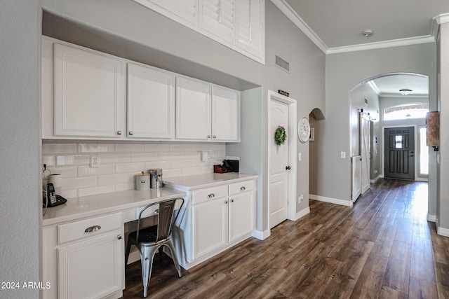 kitchen with tasteful backsplash, white cabinetry, dark hardwood / wood-style floors, and crown molding