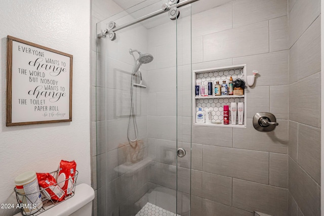 bathroom with a shower with door and toilet