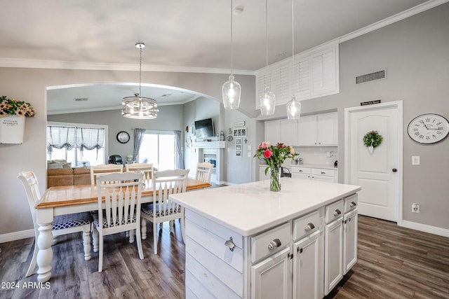 kitchen featuring a kitchen island, pendant lighting, white cabinetry, lofted ceiling, and backsplash