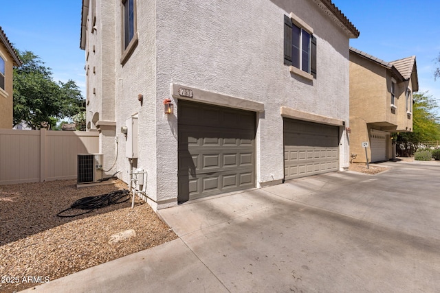 753 N Port Dr, Gilbert, AZ 85233 - view of side of property featuring stucco siding, an attached garage, driveway, and central AC