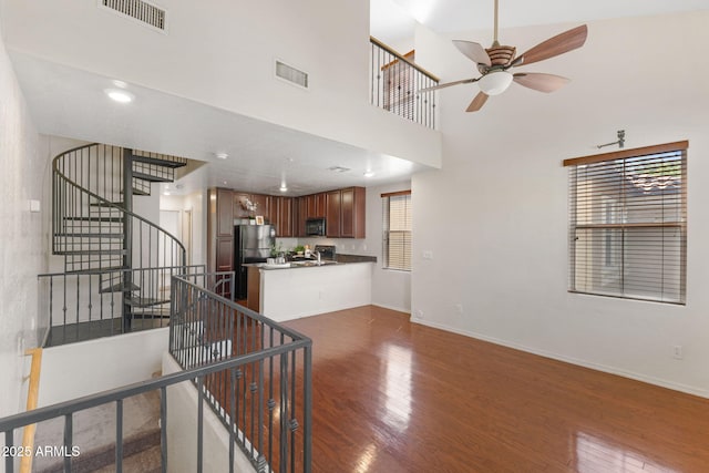 753 N Port Dr, Gilbert, AZ 85233 - kitchen featuring black microwave, dark wood finished floors, ceiling fan, a peninsula, and a towering ceiling