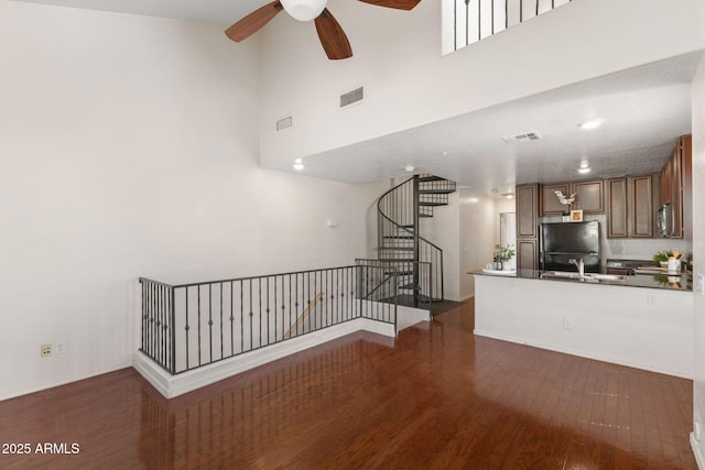 753 N Port Dr, Gilbert, AZ 85233 - unfurnished living room featuring a ceiling fan, dark wood-type flooring, stairs, a sink, and a towering ceiling