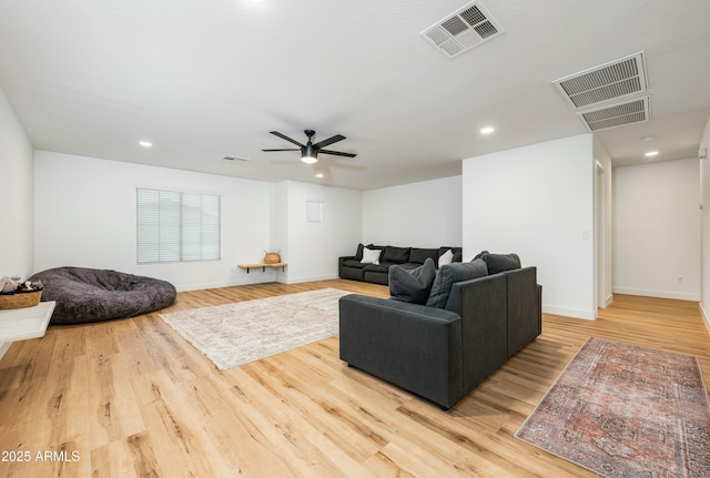 living area featuring visible vents and wood finished floors