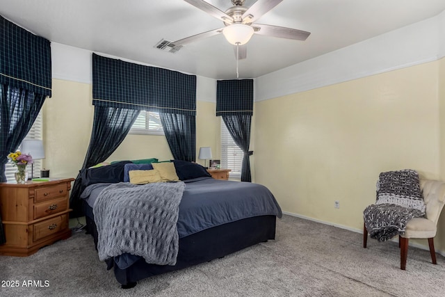 carpeted bedroom with a ceiling fan, visible vents, and baseboards