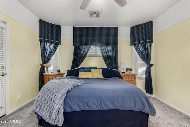 carpeted bedroom with baseboards, multiple windows, visible vents, and a ceiling fan
