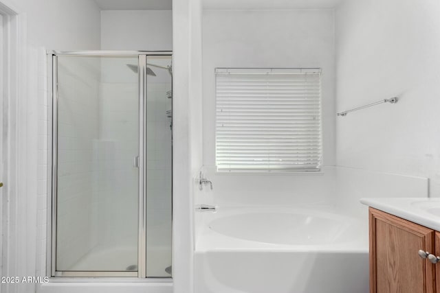 full bathroom with a shower stall, vanity, and a bath