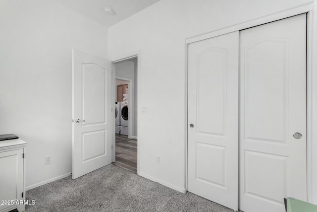 unfurnished bedroom featuring a closet, carpet, washing machine and clothes dryer, and baseboards