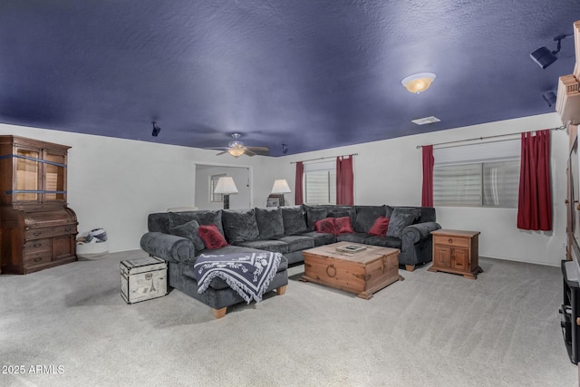 carpeted living room featuring visible vents, ceiling fan, and a textured ceiling