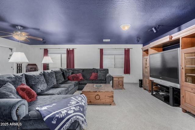carpeted living room featuring ceiling fan and a textured ceiling