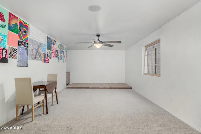interior space featuring a ceiling fan and carpet flooring