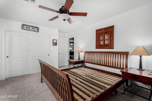 carpeted bedroom with ceiling fan, visible vents, and a closet