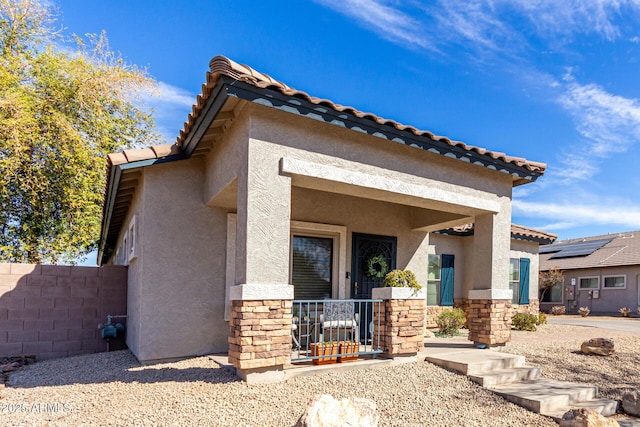 view of front of home with stone siding, a tiled roof, and stucco siding