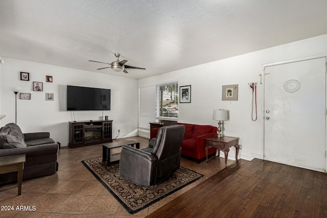 living room featuring ceiling fan and a textured ceiling