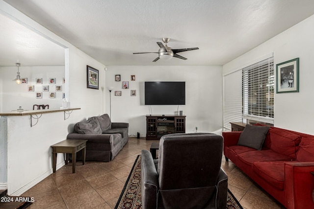 living room featuring a fireplace and ceiling fan