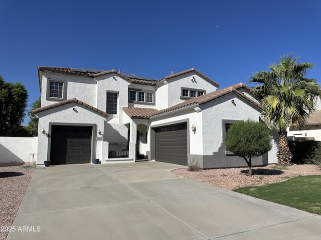 mediterranean / spanish-style home featuring solar panels, a tile roof, stucco siding, driveway, and a gate