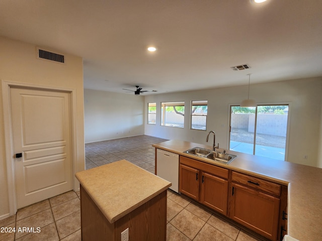 kitchen with sink, white dishwasher, a healthy amount of sunlight, and decorative light fixtures