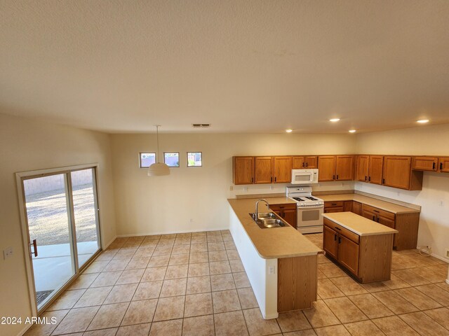 kitchen with white appliances, sink, light tile patterned floors, decorative light fixtures, and a kitchen island