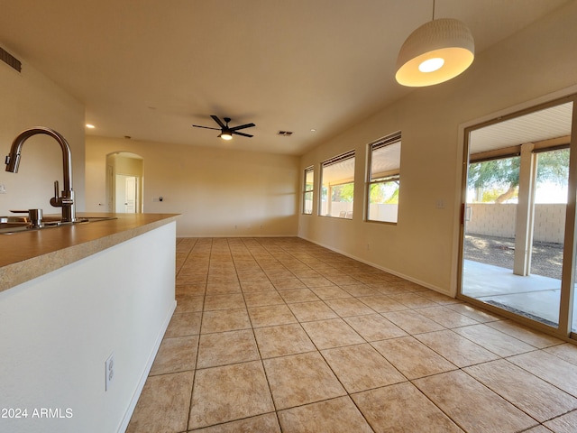 interior space with ceiling fan, light tile patterned floors, and sink