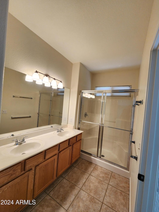 bathroom with tile patterned floors, vanity, and a shower with door