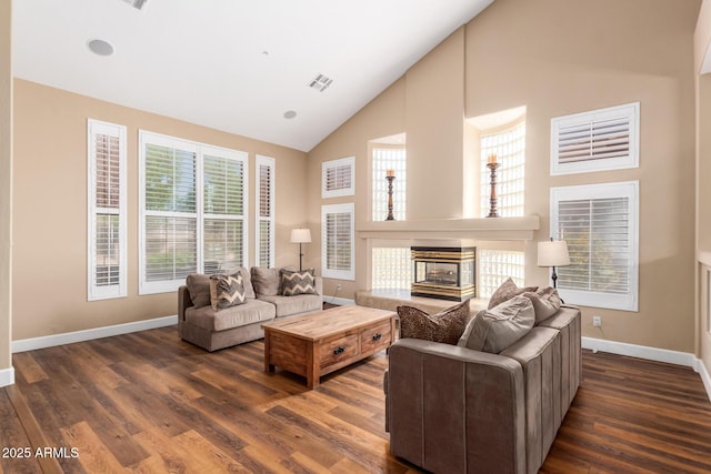 24916 N 80th Ln, Peoria, AZ 85383 - living area with high vaulted ceiling, baseboards, dark wood-style flooring, plenty of natural light, and a multi sided fireplace