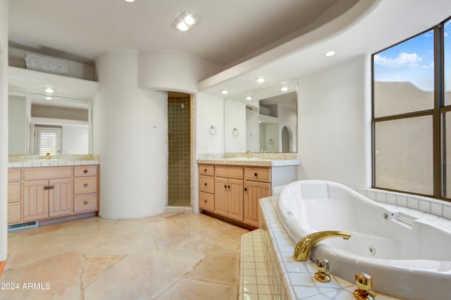 bathroom with vanity and tiled bath