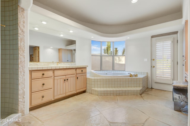 bathroom with tiled tub and vanity