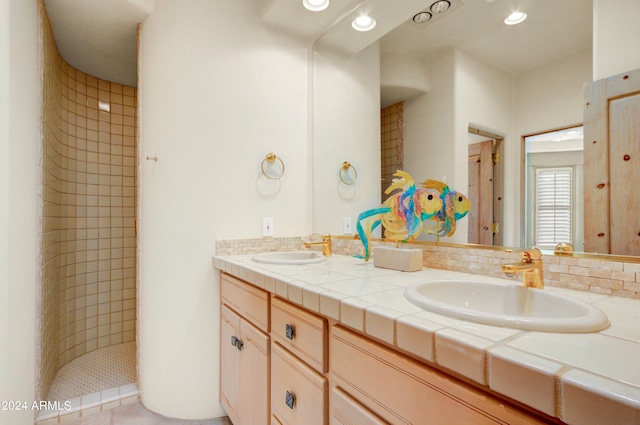 bathroom with a tile shower, tile patterned floors, tasteful backsplash, and vanity